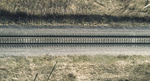 Высокий воздушный взгляд трутня железной дороги через населенные пункты сельского типа леса весны стоковое изображение Высокий воздушный взгляд трутня железной дороги через населенные пункты сельского типа леса весны стоковое изображение