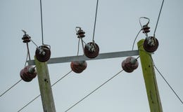 Высоковольтные электрические кабели и изоляторы электропитания увиденные на деревянных поляках стоковые изображения rf Высоковольтные электрические кабели и изоляторы электропитания увиденные на деревянных поляках стоковые изображения rf