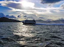 Высокоскоростной паром едет в вечере через море от острова Гонконга к Макао стоковая фотография Высокоскоростной паром едет в вечере через море от острова Гонконга к Макао стоковая фотография