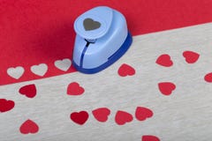 Вычисляемый пластичный бумажный пунш и handmade красные сердца стоковое изображение Вычисляемый пластичный бумажный пунш и handmade красные сердца стоковое изображение