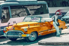 Гавана, Куба - SEPT. 2017: Старый винтажный ретро американский автомобиль апельсина 1950s, touristic автобусов на предпосылке стоковые фотографии rf Гавана, Куба - SEPT. 2017: Старый винтажный ретро американский автомобиль апельсина 1950s, touristic автобусов на предпосылке стоковые фотографии rf