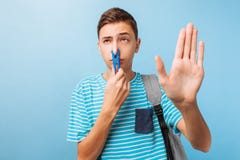 Гай закрыл его нос с зажимкой для белья, плохим запахом, на светлом - голубая предпосылка стоковая фотография rf Гай закрыл его нос с зажимкой для белья, плохим запахом, на светлом - голубая предпосылка стоковая фотография rf