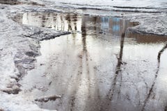 Глубокая лужица со снегом шишек плавит на дороге в городе стоковая фотография rf Глубокая лужица со снегом шишек плавит на дороге в городе стоковая фотография rf