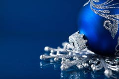 Голубые и серебряные орнаменты рождества на синей предпосылке стоковая фотография Голубые и серебряные орнаменты рождества на синей предпосылке стоковая фотография