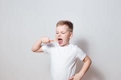 6 годовалое в белой футболке чистя ее рот щеткой зубов широкий открытый стоковые изображения 6 годовалое в белой футболке чистя ее рот щеткой зубов широкий открытый стоковые изображения