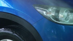 Голубой автомобиль компакта SUV с стиркой спорта и современного дизайна с брызгом воды от высокой шайбы давления на самообслужива Голубой автомобиль компакта SUV с стиркой спорта и современного дизайна с брызгом воды от высокой шайбы давления на самообслужива