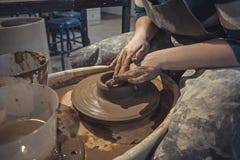 Гончар женщины мастера в рисберме на работе Художник мастера формирует кувшин с его руками на колесе гончарни стоковое изображение Гончар женщины мастера в рисберме на работе Художник мастера формирует кувшин с его руками на колесе гончарни стоковое изображение