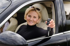 Гордый водитель женщины задерживая ее ключи автомобиля стоковая фотография rf Гордый водитель женщины задерживая ее ключи автомобиля стоковая фотография rf
