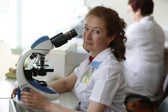 Город 1-ое июня 2016 Беларуси Gomel, региональная больница Исследователь женщины смотрит в микроскопе Расследуйте испытания изобр стоковая фотография rf Город 1-ое июня 2016 Беларуси Gomel, региональная больница Исследователь женщины смотрит в микроскопе Расследуйте испытания изобр стоковая фотография rf