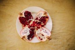 Гранатовые деревья на белой плите, предпосылка Cutted красные зрелые бумаги ремесла, взгляд сверху стоковые изображения rf Гранатовые деревья на белой плите, предпосылка Cutted красные зрелые бумаги ремесла, взгляд сверху стоковые изображения rf