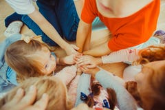 Группа в составе дети кладя их руки совместно стоковые фото Группа в составе дети кладя их руки совместно стоковые фото