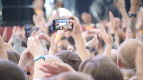 Группа в составе молодые люди наслаждаясь внешним музыкальным фестивалем Вид сзади конца-вверх толпы на концерте Смешные люди сни стоковое фото rf Группа в составе молодые люди наслаждаясь внешним музыкальным фестивалем Вид сзади конца-вверх толпы на концерте Смешные люди сни стоковое фото rf