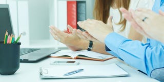 Группа в составе предприниматели сидя в ряд на представлении и хлопать Как раз руки над таблицей стоковое изображение Группа в составе предприниматели сидя в ряд на представлении и хлопать Как раз руки над таблицей стоковое изображение