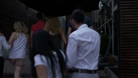 Группа в составе радостные люди идя на улицу ища клуб и входит в для того чтобы party сток-видео Группа в составе радостные люди идя на улицу ища клуб и входит в для того чтобы party сток-видео