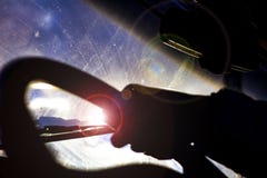 Грязное поцарапанное лобовое стекло автомобиля со счищателем через запачканный руль с рукой водителя на запачканной предпосылке стоковое фото Грязное поцарапанное лобовое стекло автомобиля со счищателем через запачканный руль с рукой водителя на запачканной предпосылке стоковое фото