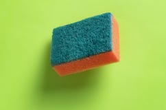 Губка для моя блюд изолированных на красочной предпосылке b стоковое изображение rf Губка для моя блюд изолированных на красочной предпосылке b стоковое изображение rf
