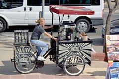 Дама на велосипеде катят 3, который продавая напитки стоковая фотография Дама на велосипеде катят 3, который продавая напитки стоковая фотография