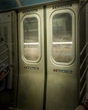 Двери метро Нью-Йорка, закрытые, пока поезд двигает, со свет-чертами видимыми через окна стоковые изображения Двери метро Нью-Йорка, закрытые, пока поезд двигает, со свет-чертами видимыми через окна стоковые изображения