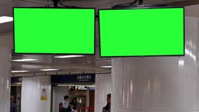 Движение людей busying для того чтобы принять поезд на ночу с зеленой доской движения экрана Движение людей busying для того чтобы принять поезд на ночу с зеленой доской движения экрана