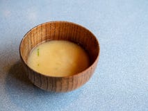 Двинутый под углом снял деревянного sipping шара заполненного с супом мисо на обеденном столе стоковое фото rf Двинутый под углом снял деревянного sipping шара заполненного с супом мисо на обеденном столе стоковое фото rf