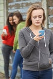 Девочка-подросток будучи задиранным текстовым сообщением стоковые фотографии rf Девочка-подросток будучи задиранным текстовым сообщением стоковые фотографии rf