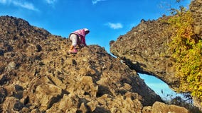 Девушка Hijab взбираясь на пике горы утеса стоковое фото rf Девушка Hijab взбираясь на пике горы утеса стоковое фото rf