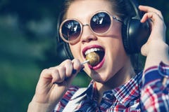 Девушка битника слушая к музыке на наушниках с леденцом на палочке стоковая фотография Девушка битника слушая к музыке на наушниках с леденцом на палочке стоковая фотография