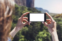 Девушка блоггера хипстера держит мобильный телефон в женских руках, фотографирует фото естественный ландшафт на солнечном перемещ стоковая фотография Девушка блоггера хипстера держит мобильный телефон в женских руках, фотографирует фото естественный ландшафт на солнечном перемещ стоковая фотография