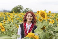 Девушка в традиционном болгарском платье в поле солнцецветов стоковая фотография rf Девушка в традиционном болгарском платье в поле солнцецветов стоковая фотография rf