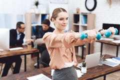 Девушка делает гимнастические тренировки на работе стоковая фотография Девушка делает гимнастические тренировки на работе стоковая фотография