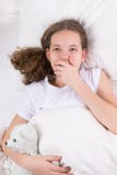 Девушка зевает в кровати и обнимает полярного медведя игрушки стоковая фотография Девушка зевает в кровати и обнимает полярного медведя игрушки стоковая фотография