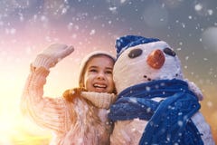 Девушка играя с снеговиком Стоковые Изображения RF Девушка играя с снеговиком Стоковые Изображения RF