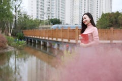 Девушка милой азиатской китайской женщины красивая на открытом воздухе сидит на траве лужайка в саде парка чувствует беспечальную стоковое изображение Девушка милой азиатской китайской женщины красивая на открытом воздухе сидит на траве лужайка в саде парка чувствует беспечальную стоковое изображение