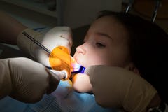 Девушка на педиатрическом офисе дантистов, обработке зубов младенца стоковое изображение Девушка на педиатрическом офисе дантистов, обработке зубов младенца стоковое изображение
