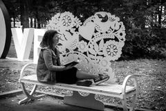Девушка на стенде в парке с книгой в ее руках, черно-белым фото стоковое фото rf Девушка на стенде в парке с книгой в ее руках, черно-белым фото стоковое фото rf