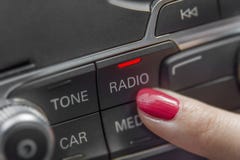 Девушка отжимая панель автомобильного радиоприемника стерео и современное оборудование приборной панели Стоковые Изображения RF Девушка отжимая панель автомобильного радиоприемника стерео и современное оборудование приборной панели Стоковые Изображения RF