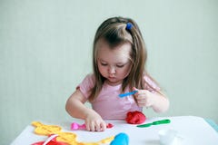 Девушка ребенка сидя на таблице играя с красочной глиной крытой, концепцией дошкольного образования и терапией искусства стоковое изображение Девушка ребенка сидя на таблице играя с красочной глиной крытой, концепцией дошкольного образования и терапией искусства стоковое изображение