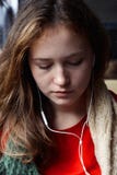 Девушка с краснокоричневыми волосами слушая музыку с его глазами закрыла стоковая фотография Девушка с краснокоричневыми волосами слушая музыку с его глазами закрыла стоковая фотография