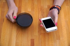 Девушка сидя в кафе таблица и выпивая черный кофе, используя ваш smartphone стоковые изображения rf Девушка сидя в кафе таблица и выпивая черный кофе, используя ваш smartphone стоковые изображения rf
