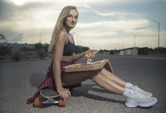 Девушка скача со скейтборда со скейтбордом или longboard headphonesGirl ни поставляет пиццу в городе стоковые фотографии rf Девушка скача со скейтборда со скейтбордом или longboard headphonesGirl ни поставляет пиццу в городе стоковые фотографии rf
