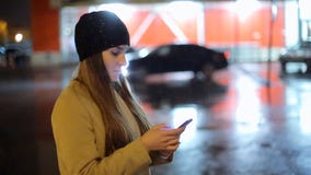 Девушка указывая палец на smartphone экрана на свете цвета bokeh освещенности фона в городе ночи атмосферическом сток-видео Девушка указывая палец на smartphone экрана на свете цвета bokeh освещенности фона в городе ночи атмосферическом сток-видео