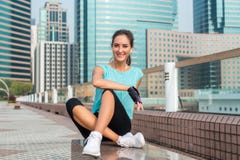 Девушка фитнеса ослабляя после встречи разминки сидя на стенде в переулке города Молодая атлетическая женщина принимая пролом от стоковая фотография Девушка фитнеса ослабляя после встречи разминки сидя на стенде в переулке города Молодая атлетическая женщина принимая пролом от стоковая фотография