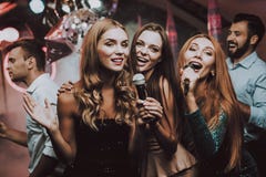 Девушки поют Имейте потеху жизнерадостно Улыбка Создатель партии стоковые изображения Девушки поют Имейте потеху жизнерадостно Улыбка Создатель партии стоковые изображения