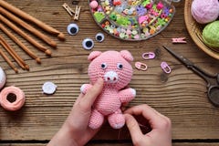 Делать розовую свинью Вяжите игрушку крючком для ребенка На таблице продевает нитку, иглы, крюк, хлопчатобумажная пряжа Раздел 2 стоковое изображение Делать розовую свинью Вяжите игрушку крючком для ребенка На таблице продевает нитку, иглы, крюк, хлопчатобумажная пряжа Раздел 2 стоковое изображение