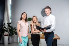 Дело, сыгранность и партнерства темы Группа в составе молодые люди, 3 люд, стойка в офисе около таблицы внутри стоковая фотография rf Дело, сыгранность и партнерства темы Группа в составе молодые люди, 3 люд, стойка в офисе около таблицы внутри стоковая фотография rf