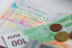 Деньги и пасспорт с штемпелями визы стоковое изображение Деньги и пасспорт с штемпелями визы стоковое изображение