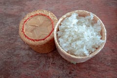 Деревянная бамбуковая коробка традиционного стиля с тайским липким рисом на деревянной предпосылке стоковая фотография Деревянная бамбуковая коробка традиционного стиля с тайским липким рисом на деревянной предпосылке стоковая фотография