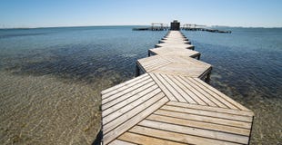 Деревянная пристань в меньшем море стоковая фотография Деревянная пристань в меньшем море стоковая фотография