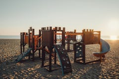 Деревянная спортивная площадка для малых детей на пляже в солнечном morni Стоковые Изображения RF Деревянная спортивная площадка для малых детей на пляже в солнечном morni Стоковые Изображения RF