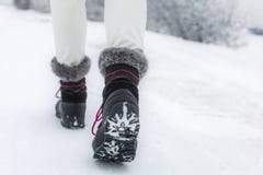 Деталь женщины поднимая ее черный и серый ботинок снега стоковые изображения rf Деталь женщины поднимая ее черный и серый ботинок снега стоковые изображения rf